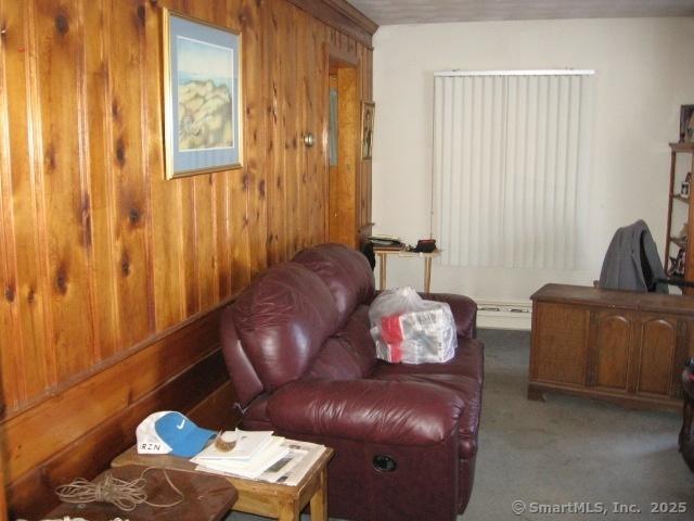 38 New Haven Rd, Seymour, CT 06483 - living room featuring wooden walls, carpet, and a baseboard radiator