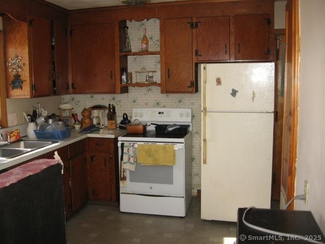 38 New Haven Rd, Seymour, CT 06483 - kitchen featuring white appliances, light countertops, tasteful backsplash, a sink, and brown cabinetry