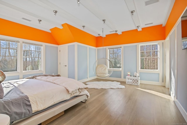 bedroom featuring multiple windows, hardwood / wood-style flooring, and vaulted ceiling