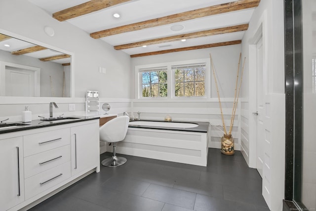 bathroom with beamed ceiling, vanity, and a washtub