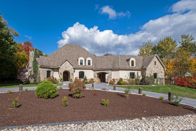 french country inspired facade featuring a front lawn