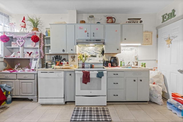 kitchen with light tile patterned flooring, white appliances, sink, and decorative backsplash