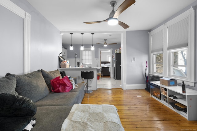 living room featuring ceiling fan and light hardwood / wood-style floors