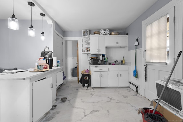 kitchen featuring white cabinetry, sink, decorative light fixtures, and a baseboard radiator