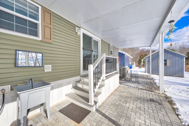 snow covered patio with an outdoor structure