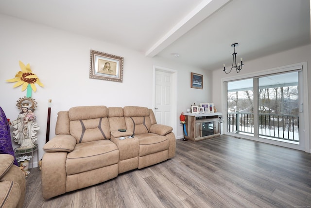 living room featuring hardwood / wood-style flooring, beam ceiling, and a chandelier