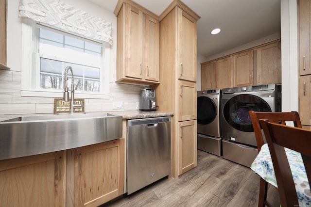 washroom featuring sink, washer and clothes dryer, and wood-type flooring