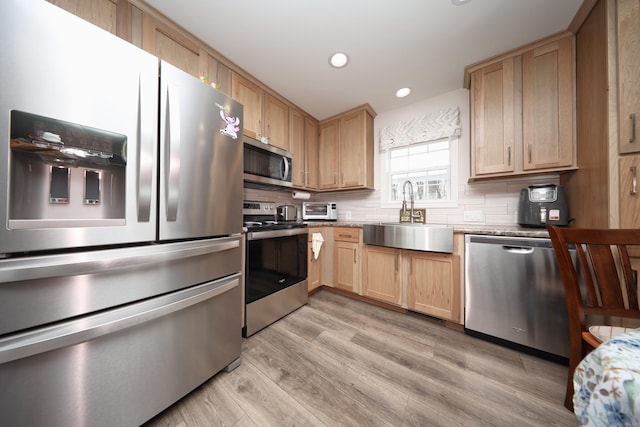 kitchen featuring sink, light hardwood / wood-style flooring, light brown cabinets, stainless steel appliances, and decorative backsplash