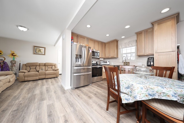 kitchen with appliances with stainless steel finishes, sink, backsplash, light hardwood / wood-style floors, and light brown cabinets