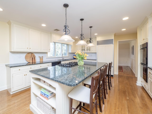 kitchen featuring black appliances, a kitchen island, and white cabinets