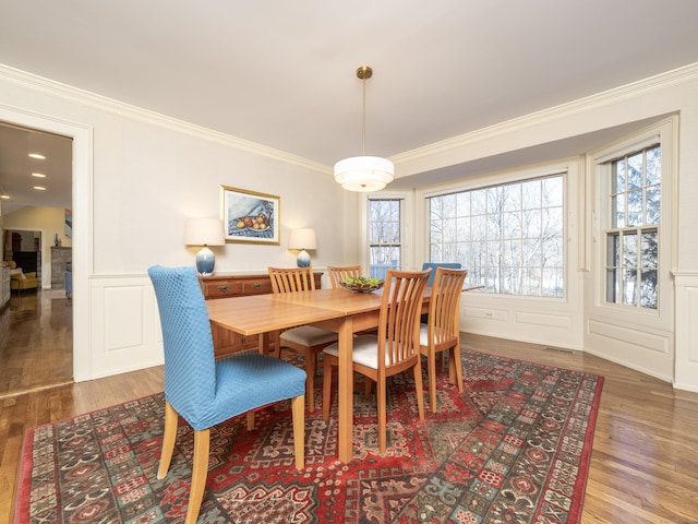 dining space with hardwood / wood-style flooring and ornamental molding