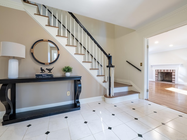 staircase featuring tile patterned floors and a brick fireplace