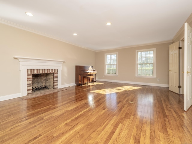 unfurnished living room featuring a brick fireplace, crown molding, and light hardwood / wood-style flooring