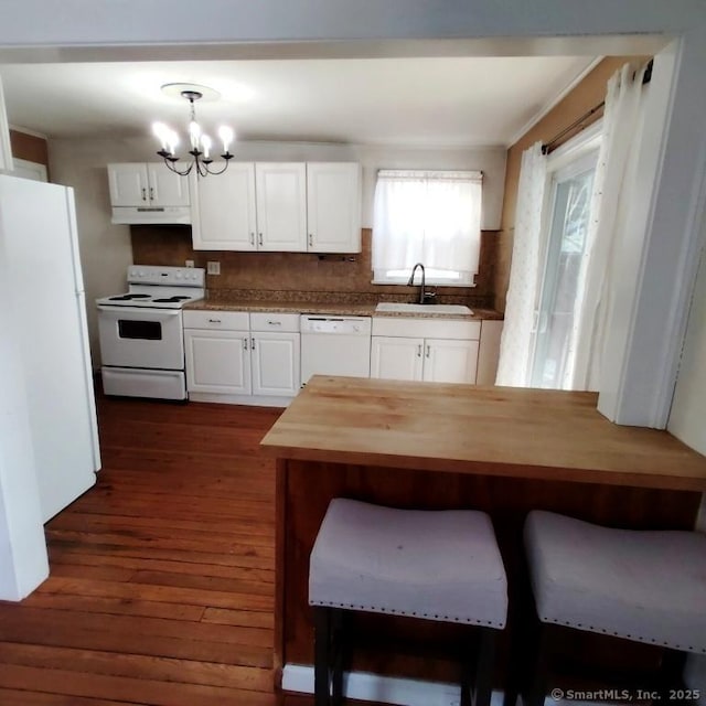 kitchen with sink, white cabinets, wooden counters, hanging light fixtures, and white appliances