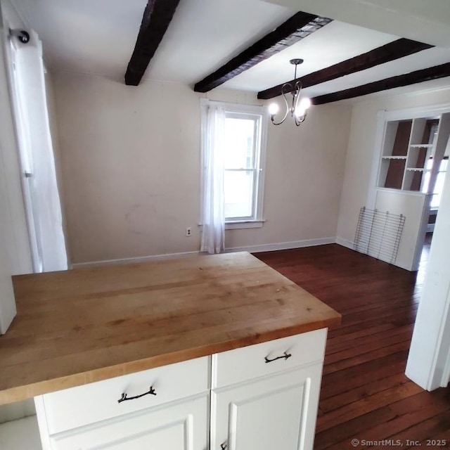 kitchen with dark hardwood / wood-style flooring, hanging light fixtures, white cabinets, wood counters, and beamed ceiling