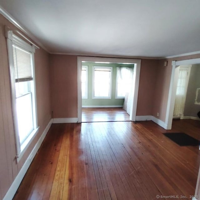 empty room featuring wood-type flooring and ornamental molding