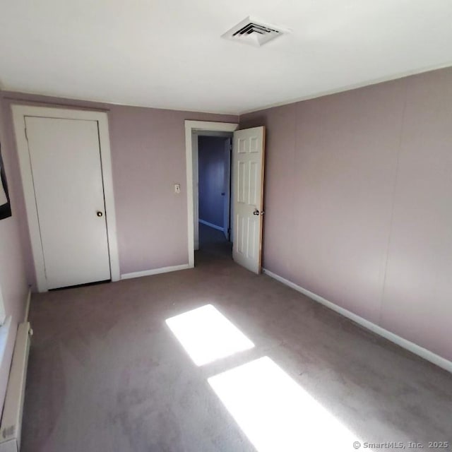 unfurnished bedroom with a baseboard radiator and carpet