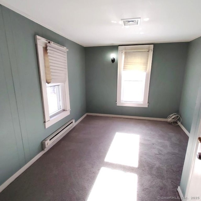 carpeted spare room with baseboard heating