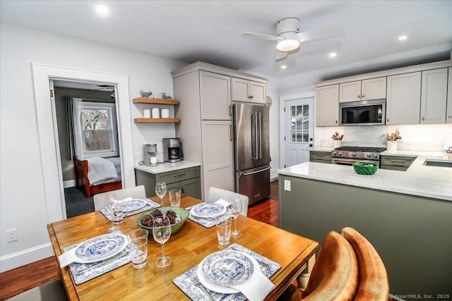 kitchen with gray cabinetry, premium appliances, sink, and ceiling fan