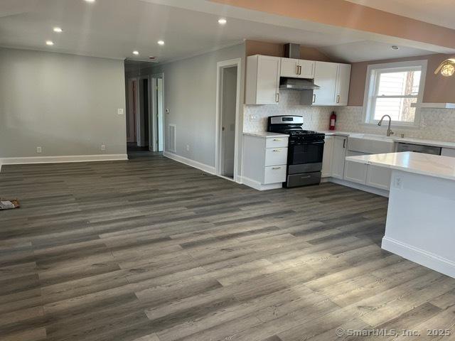 kitchen featuring gas range, white cabinetry, dark wood-type flooring, and sink