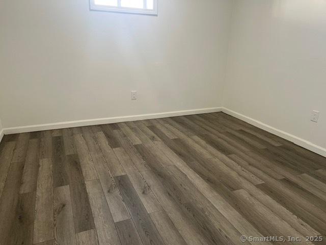 unfurnished room with dark hardwood / wood-style floors