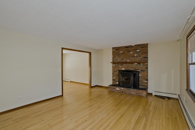 unfurnished living room with a baseboard radiator, a textured ceiling, and light hardwood / wood-style flooring