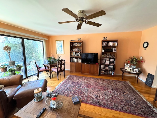 living room featuring wood-type flooring and ceiling fan