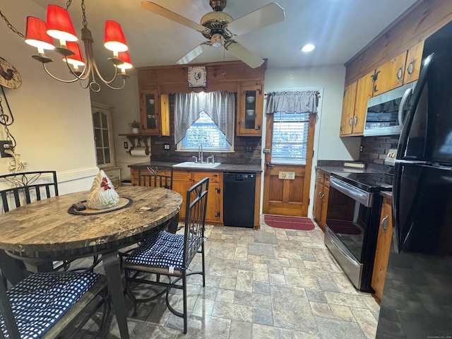 kitchen featuring tasteful backsplash, sink, pendant lighting, and black appliances