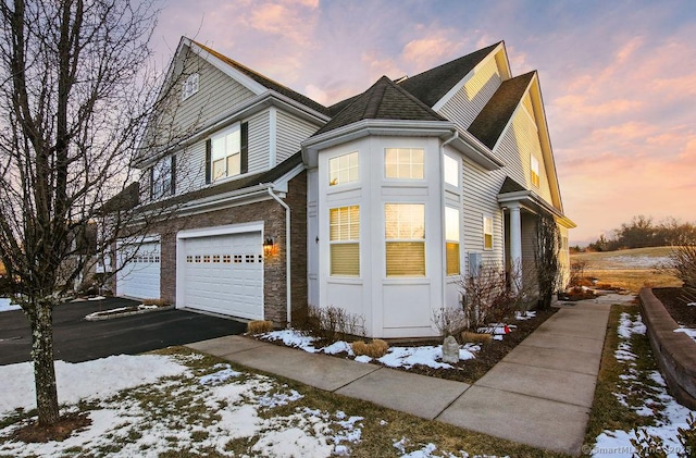 view of snowy exterior featuring a garage