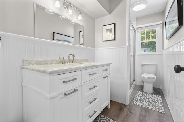 bathroom with vanity, toilet, an enclosed shower, and hardwood / wood-style floors