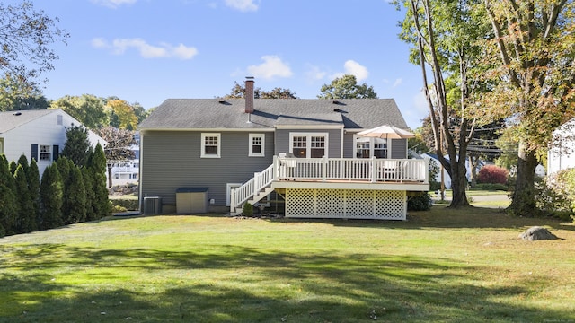 rear view of property with central AC, a deck, and a lawn