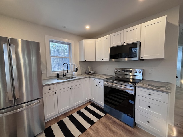 kitchen with sink, stainless steel appliances, and white cabinets