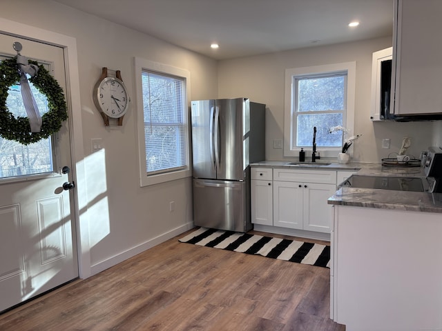 kitchen with sink, stainless steel fridge, stove, white cabinets, and dark hardwood / wood-style flooring