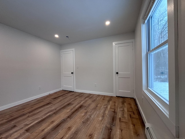 spare room with a baseboard radiator and wood-type flooring