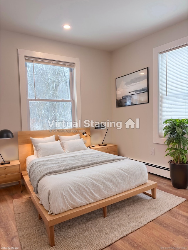 bedroom featuring hardwood / wood-style flooring and a baseboard radiator