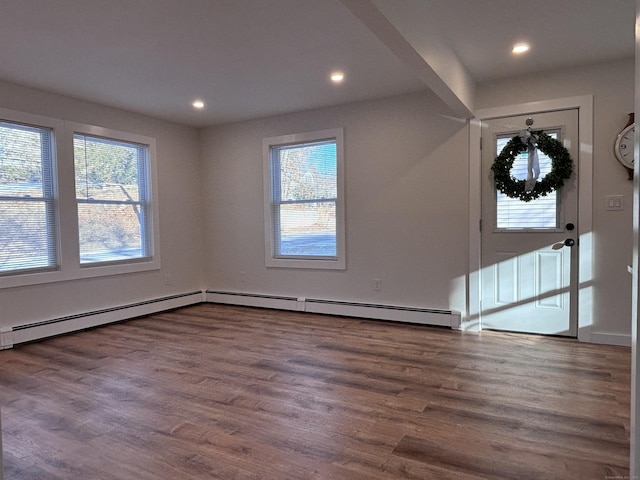 foyer entrance with a baseboard radiator and dark wood-type flooring