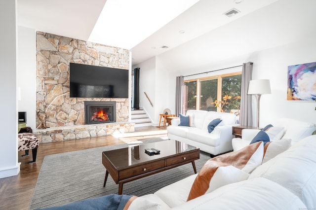 living room featuring hardwood / wood-style floors and a stone fireplace