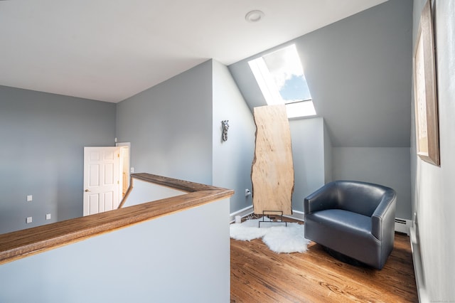 sitting room featuring baseboard heating, lofted ceiling, and light hardwood / wood-style floors