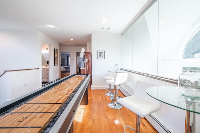 playroom featuring a baseboard radiator and light hardwood / wood-style floors