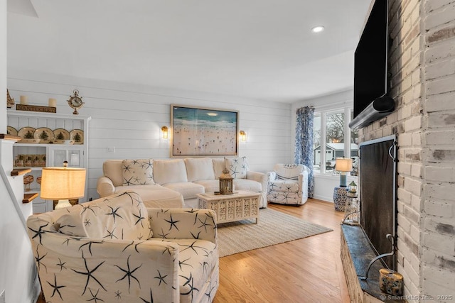 living room featuring a fireplace and light wood-type flooring