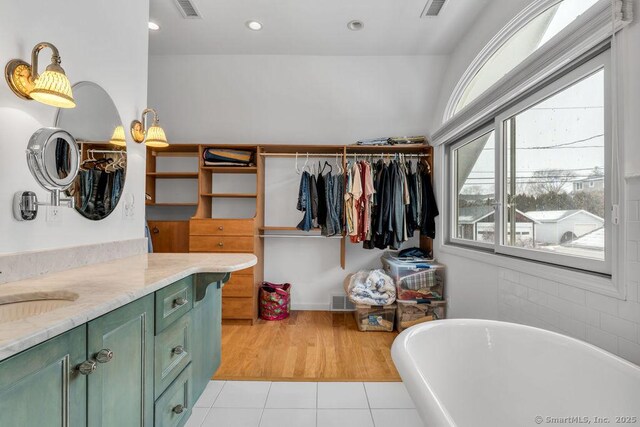 bathroom with vanity, tile patterned flooring, and a bathing tub