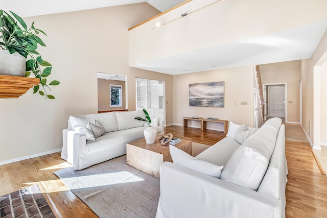 living room featuring light hardwood / wood-style flooring and high vaulted ceiling