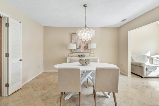 dining room featuring a chandelier, a textured ceiling, and light tile patterned floors