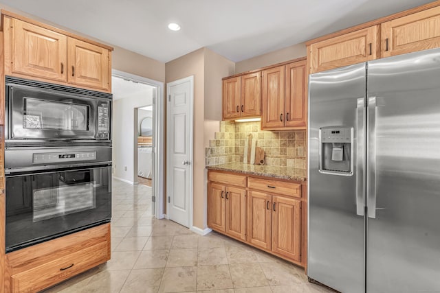 kitchen with light brown cabinetry, backsplash, light tile patterned floors, light stone counters, and black appliances