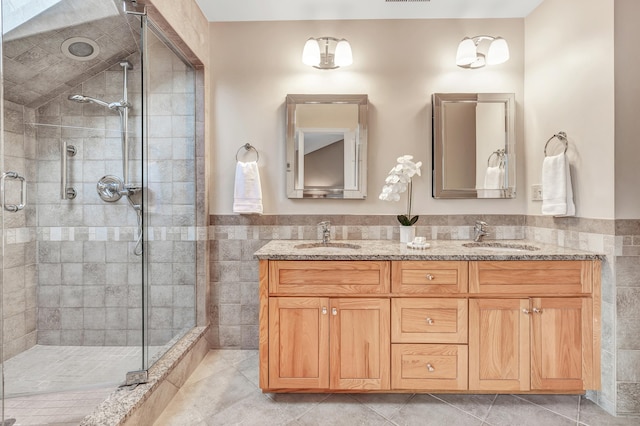 bathroom with tile walls, vanity, tile patterned flooring, and a shower with shower door