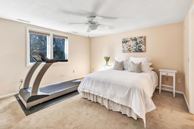 carpeted bedroom with ceiling fan and a textured ceiling