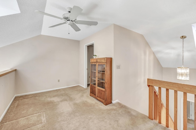 bonus room featuring lofted ceiling, ceiling fan with notable chandelier, and light carpet