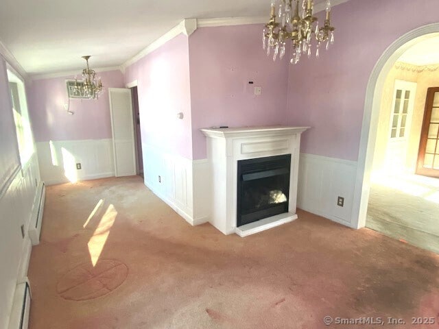 unfurnished living room with a baseboard radiator, ornamental molding, light colored carpet, and a notable chandelier