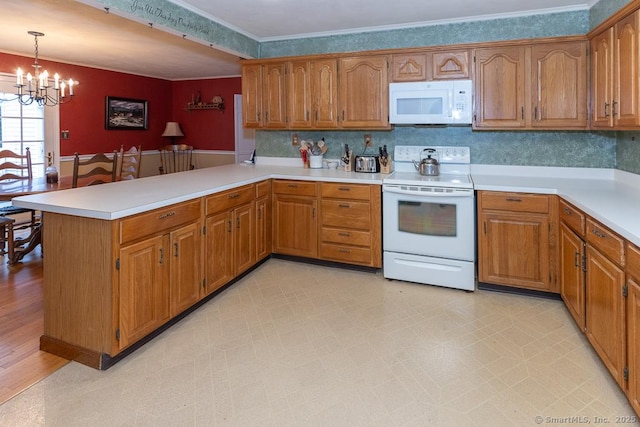 kitchen featuring white appliances, a notable chandelier, ornamental molding, decorative light fixtures, and kitchen peninsula