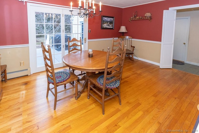 dining area with a notable chandelier, a baseboard radiator, light hardwood / wood-style floors, and ornamental molding